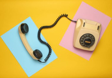 Pastel renkli bir arka plan üzerinde 80s Retro döner telefondan. Üstten Görünüm, minimalis