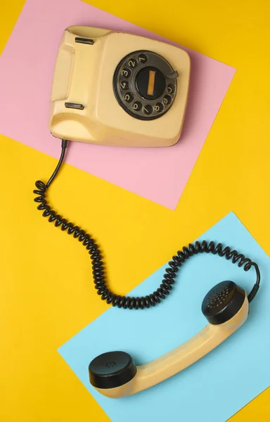 Retro rotary phone from 80s on a colored pastel background. Top view, minimalis