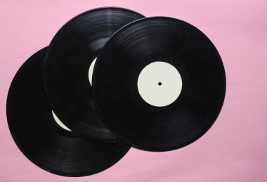 Pastel pembe bir arka plan üzerinde üç retro vinil kayıtlar. Top Vie