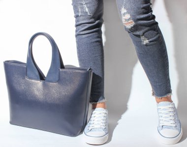 Kot pantolon ve spor ayakkabı beyaz bir adam bir torba ile poz kadın bacaklar