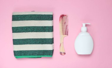 Banyo Aksesuarları Pembe bir arka plan üzerinde. Havlu, saç fırçası, şişe şampuan. Saç Bakımı. Üstten Görünüm
