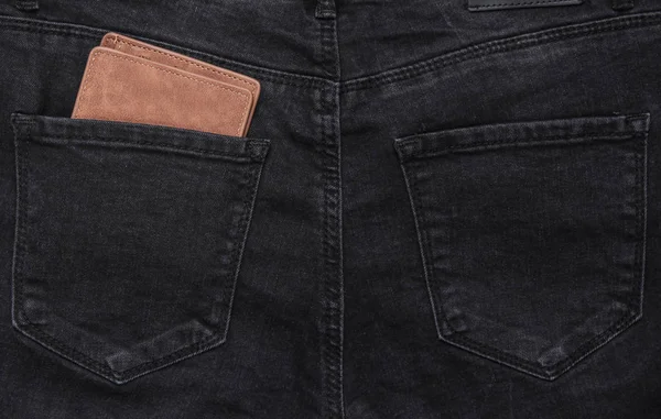 Leather wallet in the back pocket of black jean