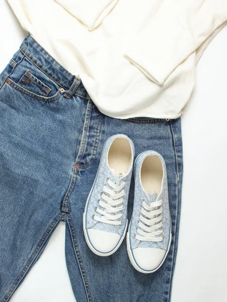 Vrouwelijke Trui Jeans Sneakers Een Witte Achtergrond Bovenaanzicht — Stockfoto