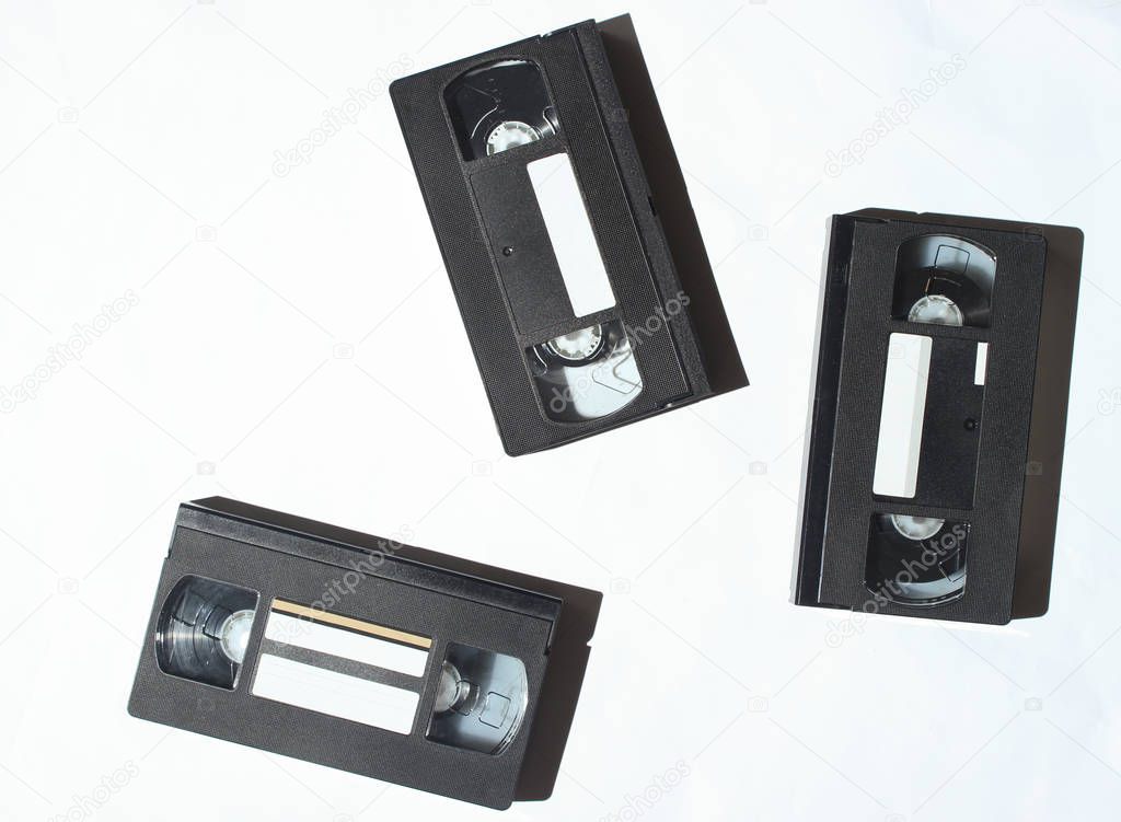 Video cassette on a white background. Retro technology. Photo with shadows, hard ligh