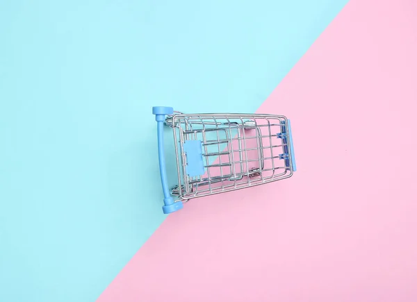 Mini shopping trolley for shopping on a colored pastel background, consumer concept, minimalism, top view