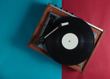 Kırmızı-mavi arka planda retro vinil plak çalar. Üstte görüntü