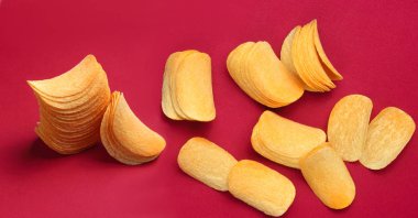 Kırmızı arka planda patates cipsi dilimleri.
