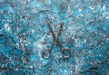 Mavi beton arka plan üzerinde eski metal makas