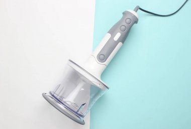 Elektrikli el blender mavi beyaz arka plan üzerinde doğrama kase bağlı. Üstte görüntü
