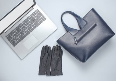 Deri çanta, eldivenler, gri arka planda dizüstü bilgisayar. İş ve moda. Üst görünüm, minimalizm