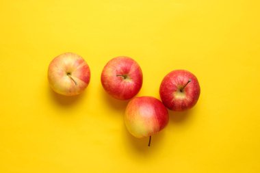 Sarı arka planda kırmızı elmalar. Sonbahar natürmortu. Üstte görüntü. 