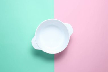 White empty bowl on pastel color background. Top view, minimalism