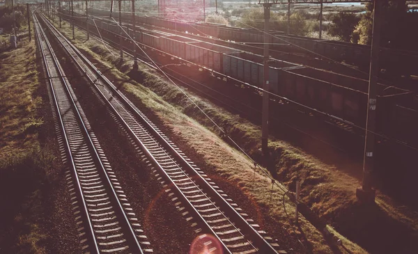 Gün batımında yük vagonları ile Endüstriyel Demiryolu. Hipster tonlama