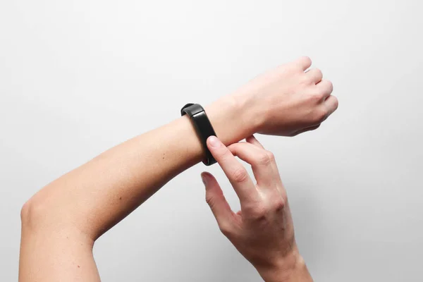 Women's hands use smart watch on gray background. Modern gadgets, top view