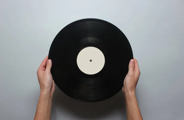 灰色の背景にレトロなビニールレコードを保持している女性の手 トップビュー ミニマリズム — ストック写真