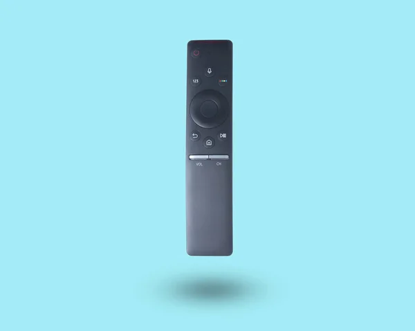 Black smart tv remote controller isolated on blue background