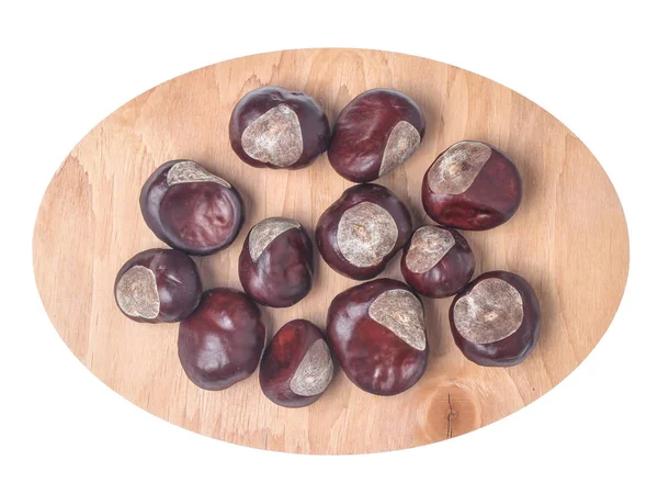 Beyaz arka plan üzerine izole ahşap bir tabak üzerinde kestane. Üstte görüntü