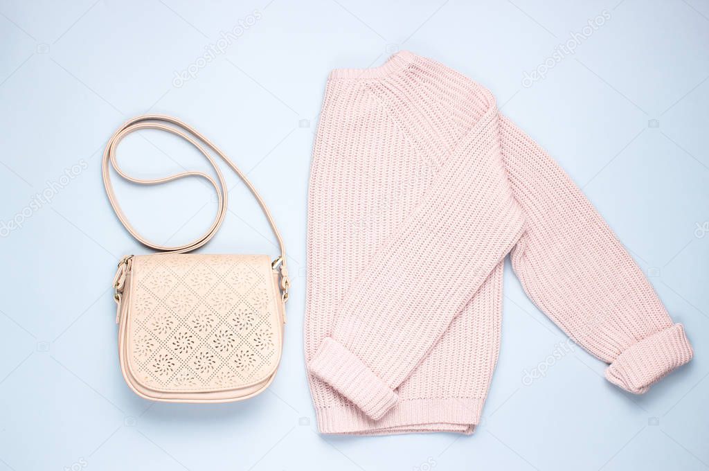 Fashionable pink pastel knitted sweater leather bag on a gray background. Top view