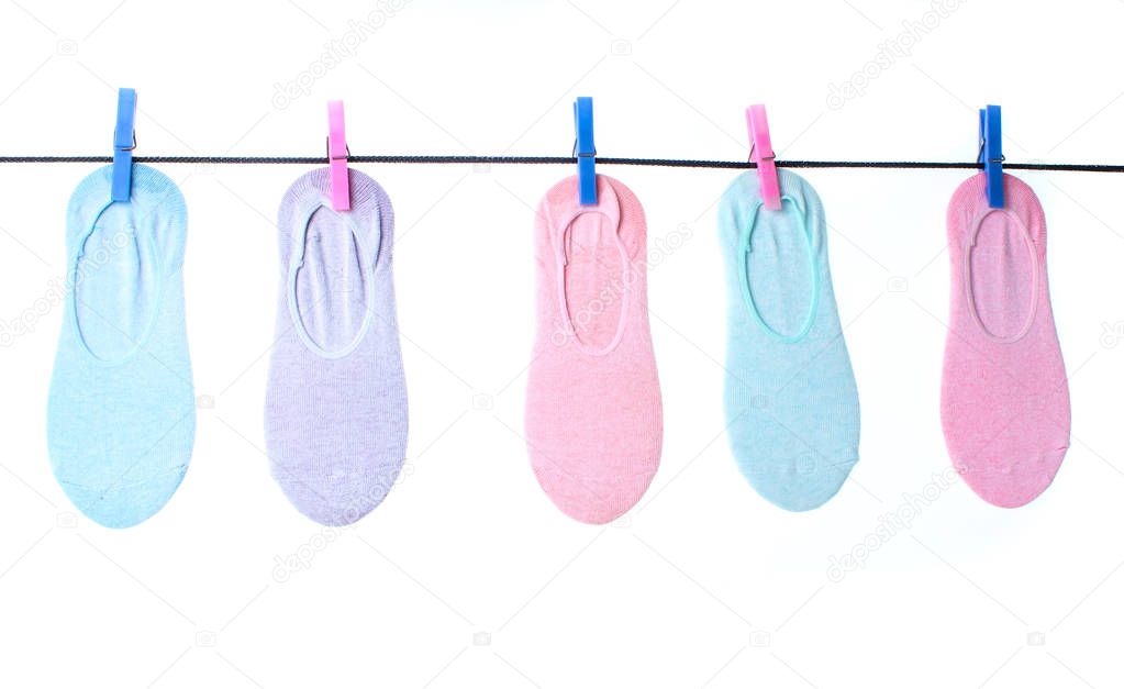 Women's  socks are hanging on clothespins clothesline isolated on white background