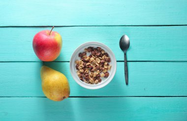 Sütte hızlı kahvaltı mısır gevreği, olgun armut, masa örtüsünde elma. mavi ahşap masa üzerinde rustik tarzı. Top vie