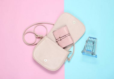 Bir çanta ve bir pastel arka plan üzerinde satın almak için bir minyatür arabası ile Şık deri çanta açın. Alışveriş kavramı, tüketici, satın alma. Üst görünüm, minimalizm