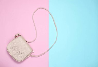 Pastel arka planda şık deri çanta. Üst görünüm, minimalizm