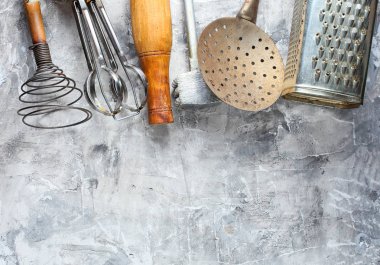 Gri beton arka plan üzerinde eski mutfak aracı. Retro mutfak, vintage pişirme aracı seti. Üstte görüntü