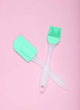 Pembe pastel arka plan üzerinde mutfak pasta silikon seti (spatula ve fırça). Üstgörünüm, minimalis