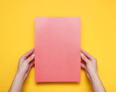 Kadın elleri sarı arka plan üzerinde polka nokta ile kağıt levha tutan. Üst te. Mockup, kopyalama alanı, minimalizm
