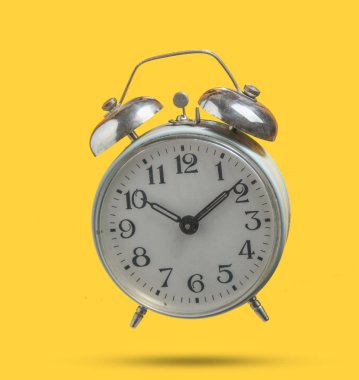 Eski retro tarzı çalar saat sarı arka plan üzerinde izole. Sabah 10:10'da. Minimalizm. Gölgeli fotoğraf