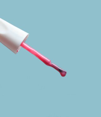 Mavi arka plan, güzellik ve moda konsepti üzerinde pembe oje Fırça. 