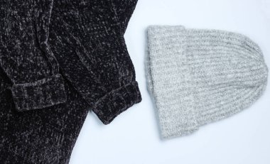 Gri bir arka plan üzerinde Velor siyah kazak ve yün sıcak şapka. Üstte görüntü.