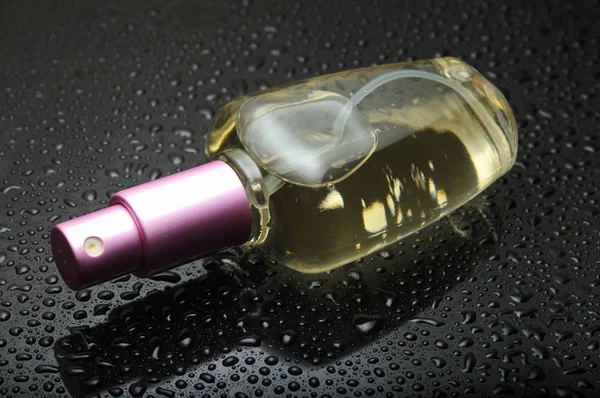 Parfümflasche Auf Schwarzem Hintergrund Mit Wassertropfen — Stockfoto