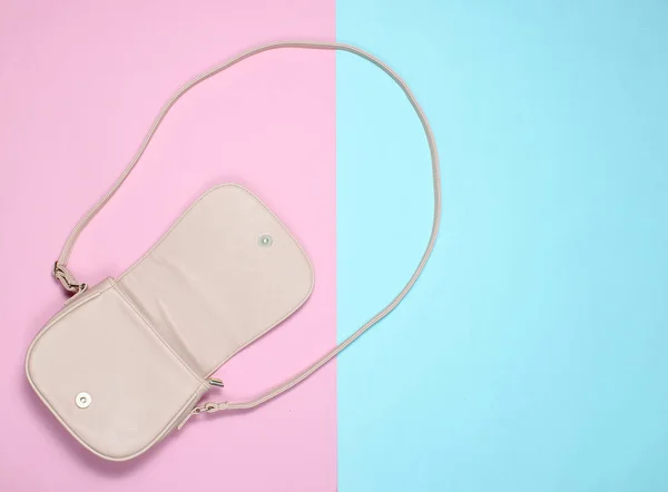 Pastel arka planda şık deri çanta açın. Üst görünüm, minimalizm