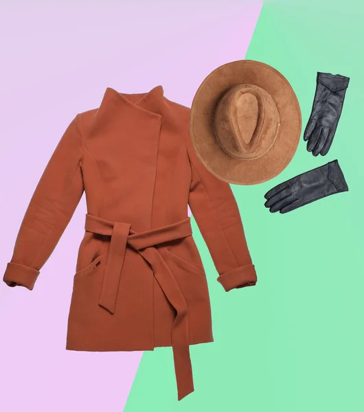 Autumn winter clothing and accessories. Brown women's cashmere coat, felt hat, leather gloves on colored neon background. Top view