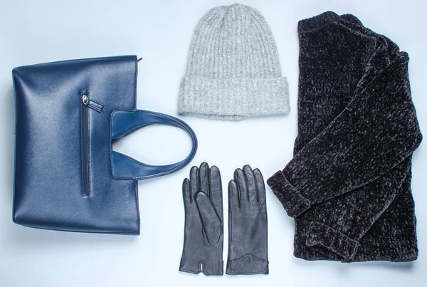 Velor black sweater, bag, leather gloves, warm wool hat on a gray background. Top view. Flat lay style