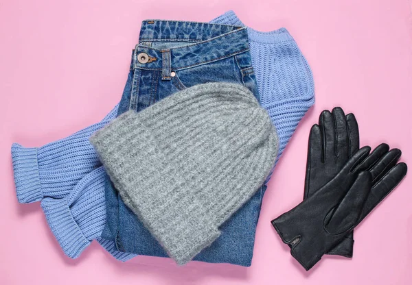 婦人服やアクセサリー 冬のウールの帽子 セーター 革手袋 ピンクの紙の背景にジーンズ ミニマリズム トップビュー フラットレイスタイル — ストック写真