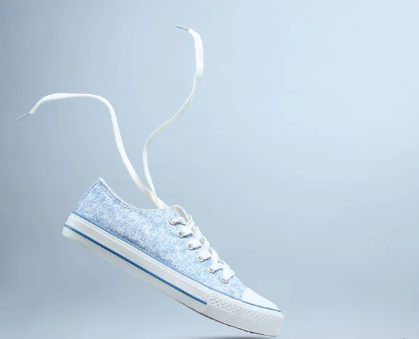 Один Білий Кросівок Плаваючі Шнурки Сірому Фоні Мінімалізм — стокове фото