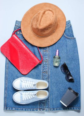 Retro tarzı, düz yatıyordu giysi, ayakkabı ve aksesuarları gri bir arka plan üzerinde 80s. Denim etek, spor ayakkabı, çanta. Minimalizm, bin yıllık