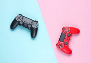 Renkli kağıt arka planda iki gamepad. Video oyunu. Minimalizm, üst görünüm