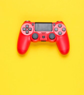 Sarı arka planda modern kırmızı gamepad (joystick). Top vie