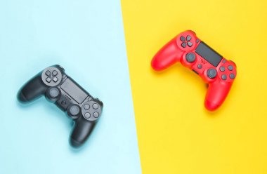 Renkli kağıt arka planda iki gamepad. Video oyunu. Minimalizm, üst görünüm