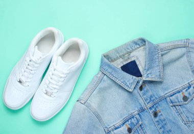 Nane renkli kağıt arka plan üzerinde Retro tarzı kot şık ceket ve beyaz hipster spor ayakkabıları. Minimalizm, üst görünüm, düz yatıyordu