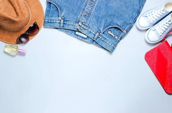 Retro tarzı, düz yatıyordu giysi, ayakkabı ve aksesuarları gri bir arka plan üzerinde 80s. Denim etek, spor ayakkabı, çanta, saksı bitkisi. Minimalizm, bin yıllık, kopyalama alanı