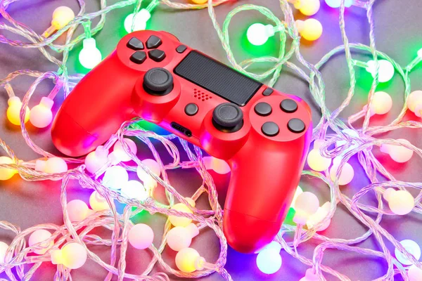 Gamepad Vermelho Entre Guirlandas Coloridas Brilhantes Lâmpadas Fundo Cinza Mínimo — Fotografia de Stock