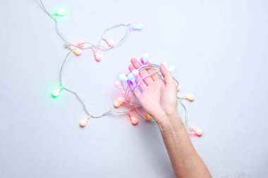 Minimalizm trendi. Kadın el gri arka plan üzerinde parlak parlayan led neon çelenk tutun. Top vie