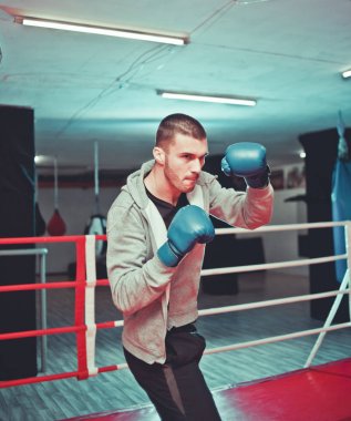 Spor salonunda ringde boks yapıyor spor adamı boksör. Bir boksör eğitim süreci. Ringde tek başına