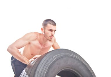 Young sports man pushing large weight wheel. training process. Isolated on white. Functional trainin