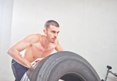Kavram fonksiyonel eğitim egzersiz salonu. Fitness adam spor salonunda lastik tekerleği flipping