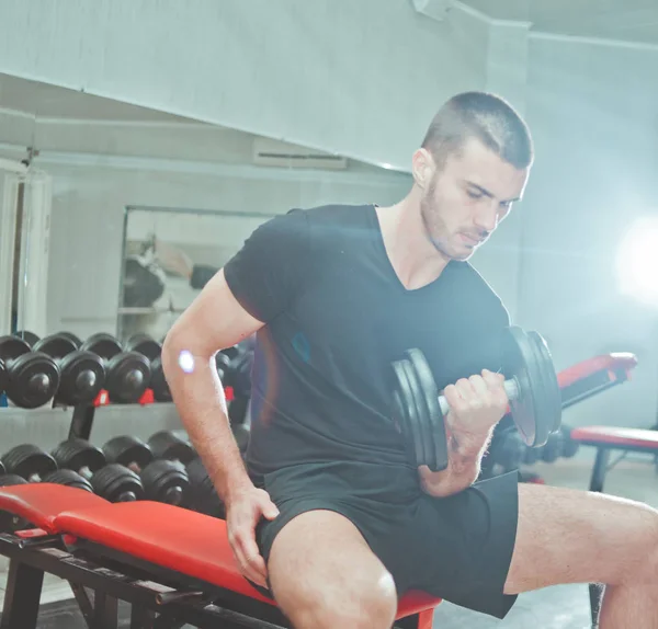 Sportowy Facet Siedzi Ławce Wykonując Jeden Biceps Stężenie Loki Hantle — Zdjęcie stockowe